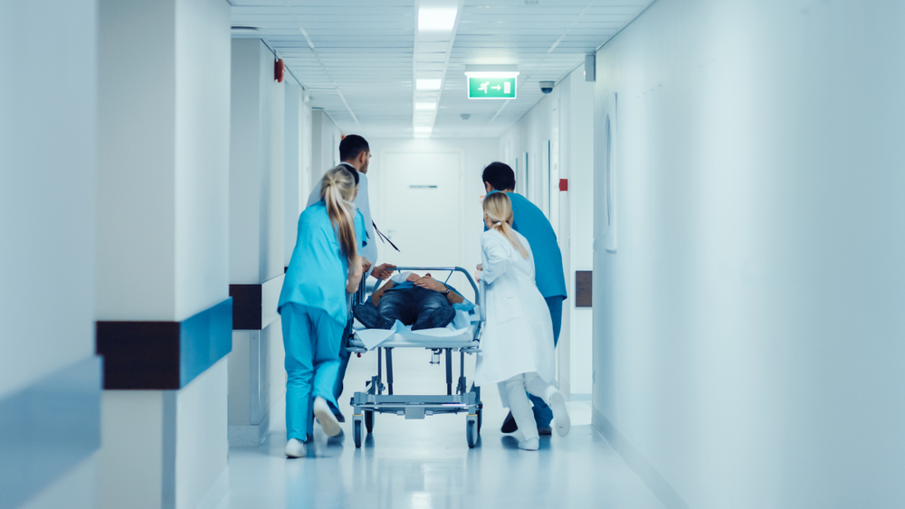 Medical team with BLS training wheeling patient through emergency room in Tempe, AZ