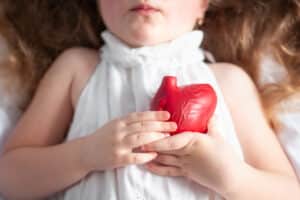 Child holding a fake heart to signify PALS training in Mesa, AZ