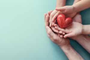 Hands holding a red heart indicating BLS training in Tempe, AZ