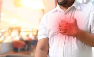 Man holding his chest due to cardiac emergency in Tempe, AZ