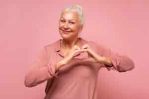 Older woman holding her hands to heart making a heart shape in Tempe, AZ